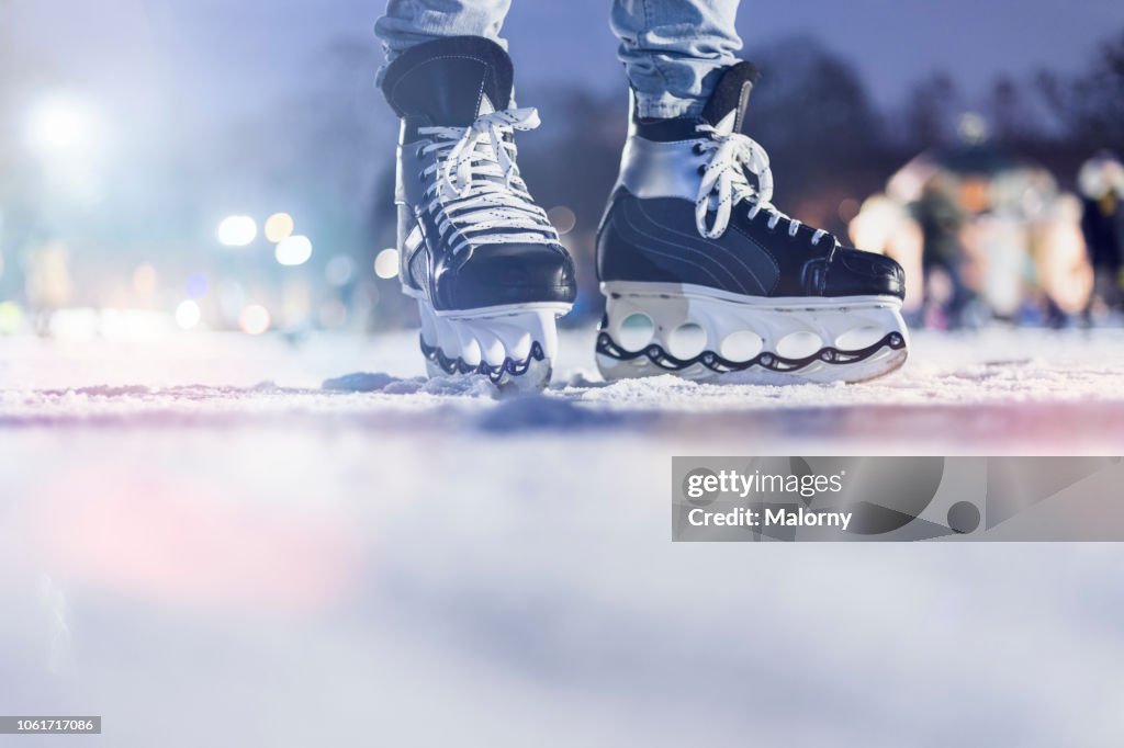 Close-up of feet and ice skates on frozen lake. Ice hockey.