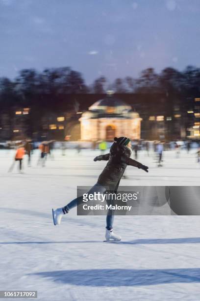 young woman ice skating on frozen lake. munich, bavaria, germany. - figure skating woman stock pictures, royalty-free photos & images