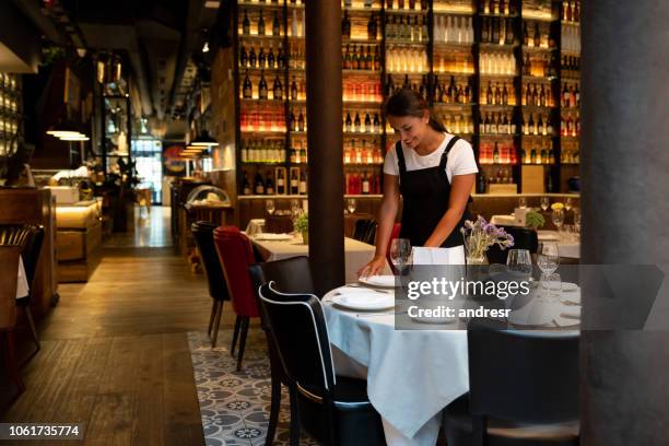 waitress working at a restaurant setting up a table - empregada de mesa imagens e fotografias de stock