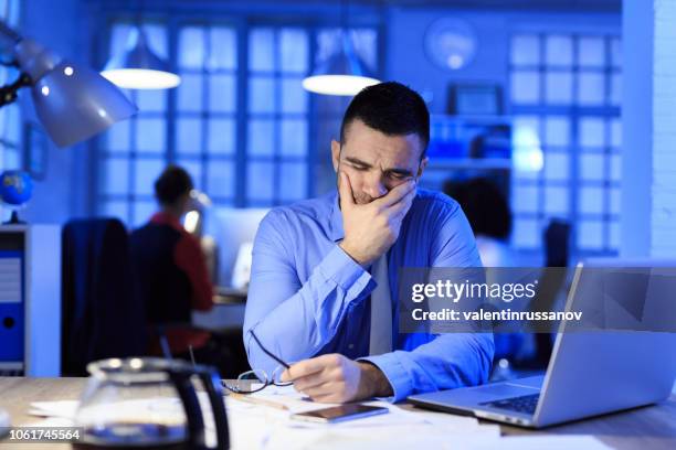 mid adult businessman working late - financial fear stock pictures, royalty-free photos & images