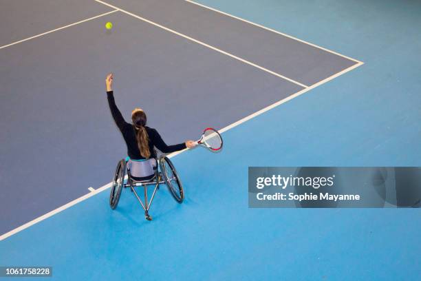 a woman in a wheelchair playing tennis - rollstuhltennis stock-fotos und bilder