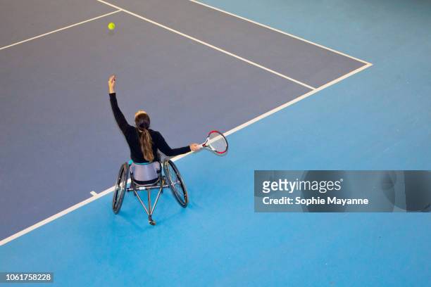 A woman in a wheelchair playing tennis