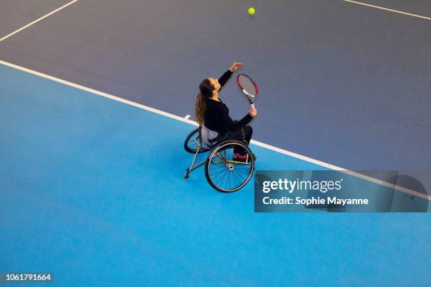 A woman in a wheelchair playing tennis