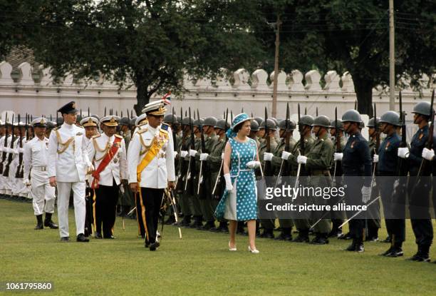 Queen Elizabeth II and Thai King Bhumipol walking down the honor guard of the Army which was welcomed by the British Queen in February 1972 in...