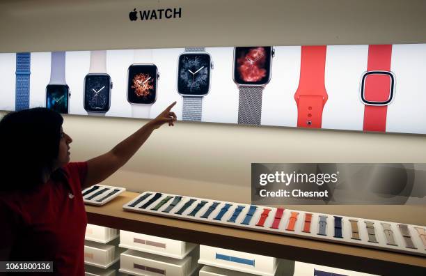 An employee shows a signage for Apple Watch during the press visit of the new Apple Store Champs-Elysees on November 15, 2018 in Paris, France. Apple...