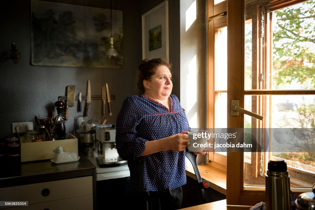 Woman by window, smiling