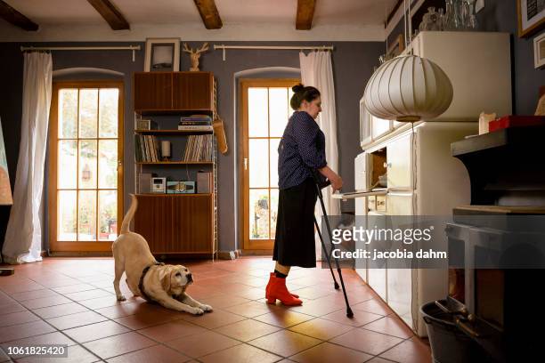 Woman with crutches, with her dog
