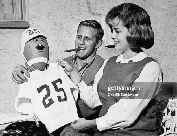 Tommy McDonald of the Philadelphia Eagles, and his wife Patricia, dress up a football with a miniature shirt and hat that bears his uniform number to...