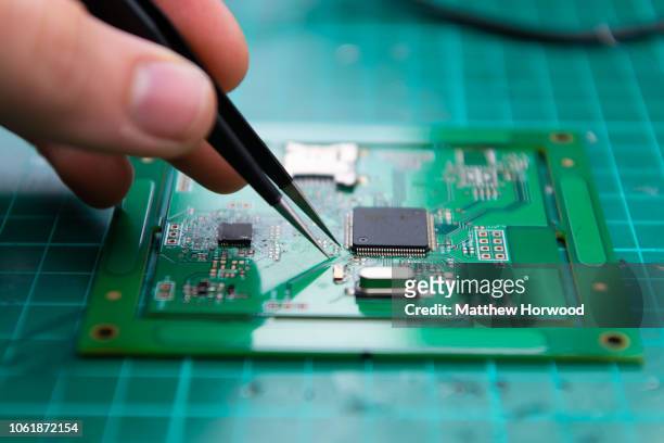 Close-up view of a technician using tweezers while working on a microchip on September 12, 2018 in Cardiff, United Kingdom.
