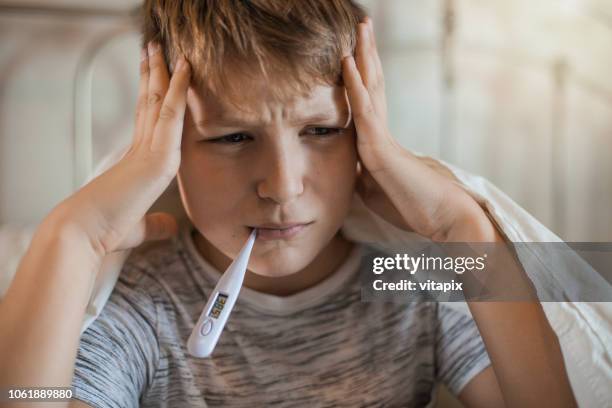 boy with a thermometer in his mouth - heat illness stock pictures, royalty-free photos & images