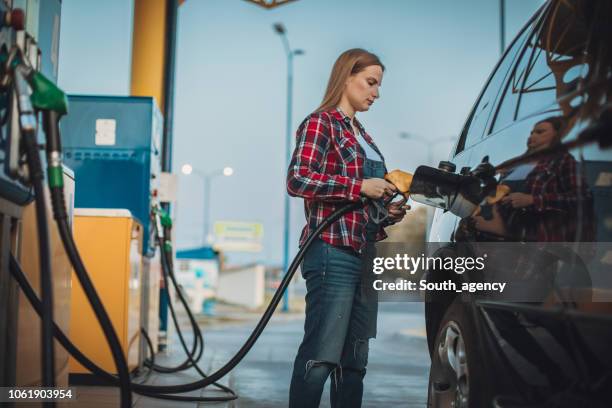 girl refueling car - refuelling stock pictures, royalty-free photos & images