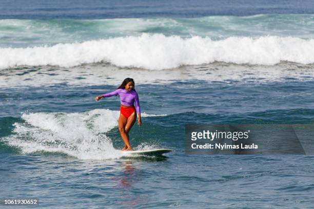 a dark skinned woman surfing
