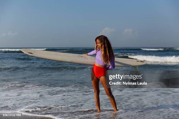 a dark skinned surfer carrying longboard - vestido cor de pele - fotografias e filmes do acervo