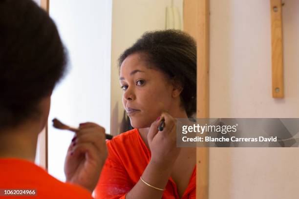 young woman putting make-up on at home - showus makeup stock pictures, royalty-free photos & images