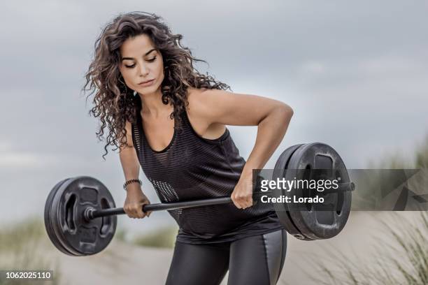 beautiful brunette woman during beach workout - muscle men at beach stock pictures, royalty-free photos & images
