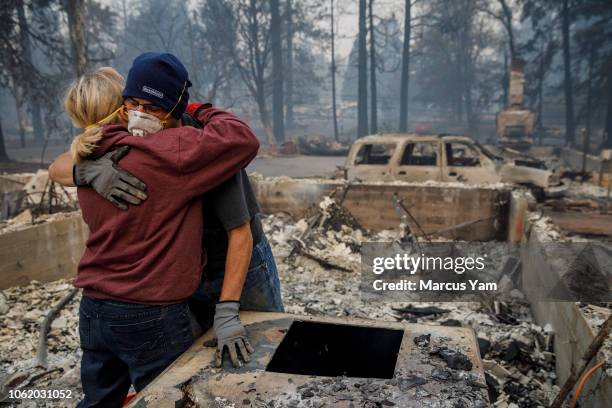 Michael John Ramirez hugs his wife Charlie Ramirez after they manage to recover her keepsake bracelet that didn't melt in the fire and held a...