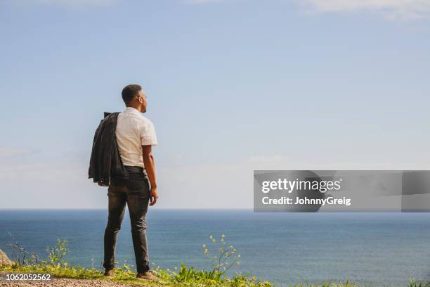 young african man looking out over sea to horizon - man look sky stock pictures, royalty-free photos & images