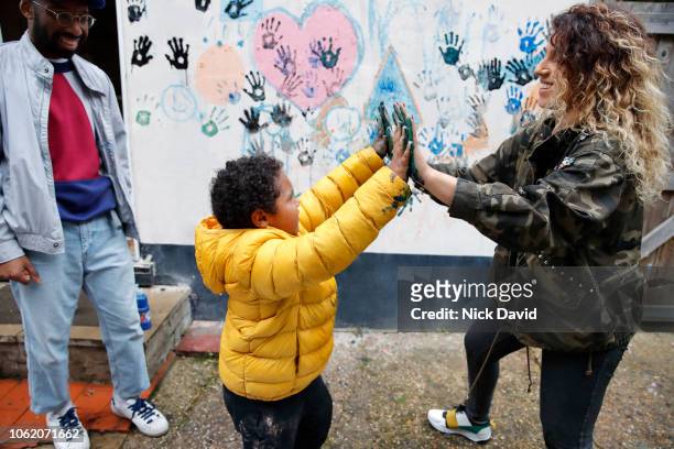 Mother and son touching hands covered in wet paint
