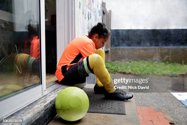 girl tying up her football boot laces on back doorstep - vrijetijd sport en spel stockfoto's en -beelden