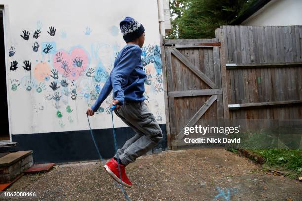boy in backyard skipping with rope - hand print on wall stock pictures, royalty-free photos & images