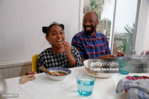 girl eating dinner with her father and smiling - finishing food stock pictures, royalty-free photos & images