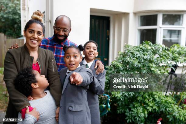 portrait of family outside house with girl pointing at camera - waist up photos stock-fotos und bilder