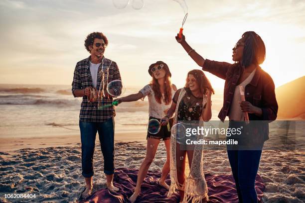 the best part of summer is spending it with friends - lens flare young people dancing on beach stock pictures, royalty-free photos & images