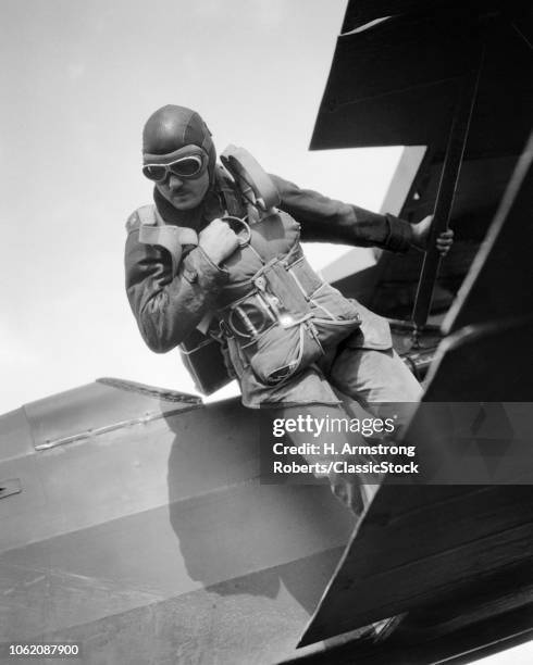 1930s 1940s ANONYMOUS MAN STANDING ON WING OF AIRPLANE ABOUT TO STEP DOWN OR JUMP OFF HIS HAND ON RIPCORD RING