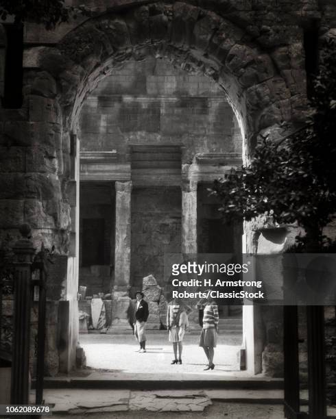 1920s MAN AND TWO WOMEN TOURISTS VISITING EXAMINING TEMPLE OF DANCE ROMAN RUINS NIMES FRANCE