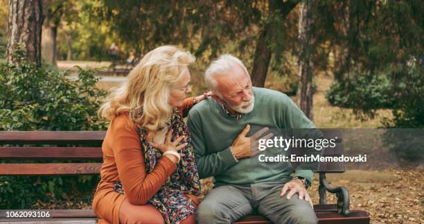 älterer mann mit schmerzen in der brust oder herzinfarkt im park - herzinfarkt stock-fotos und bilder