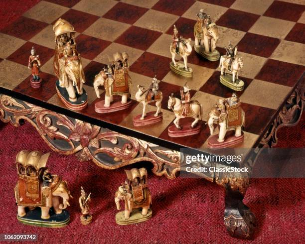 1950s CHESS SET IN STYLE OF INDIA ELEPHANTS AND MAHARAJA HUNTING PARTY ON RAISED ORNATE CHESSBOARD