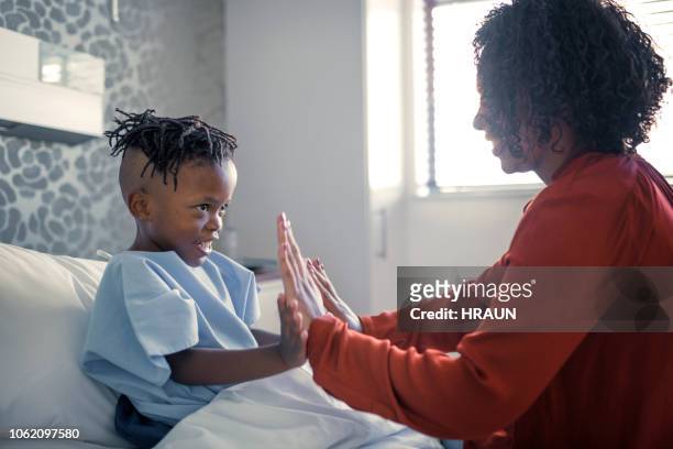 smiling boy playing with mother in hospital - childrens hospital stock pictures, royalty-free photos & images