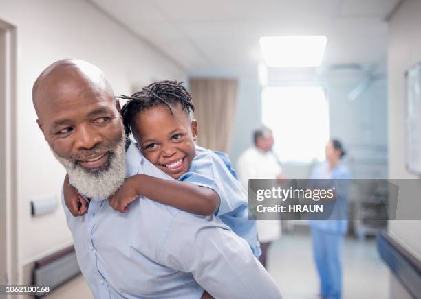 vater sohn im krankenhaus huckepack einzuräumen. - doctor african child stock-fotos und bilder