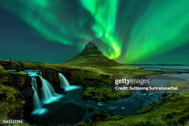 northern lights appear over mount kirkjufell with kirkjufellfoss waterfall in iceland. - reykjavik stockfoto's en -beelden