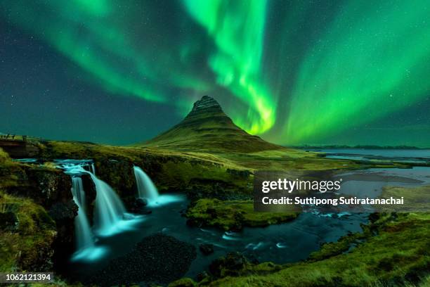 northern lights appear over mount kirkjufell with kirkjufellfoss waterfall in iceland. - reykjavik stock pictures, royalty-free photos & images
