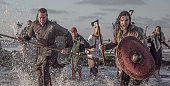 A hoard of Weapon wielding viking warriors fighting in a battlefield scene in the sea