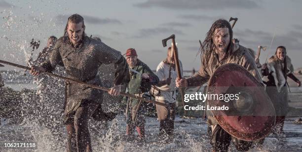 a hoard of weapon wielding viking warriors fighting in a battlefield scene in the sea - vikings stock pictures, royalty-free photos & images