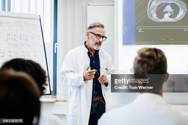 doctor talking to medical students - doctor speech stock pictures, royalty-free photos & images