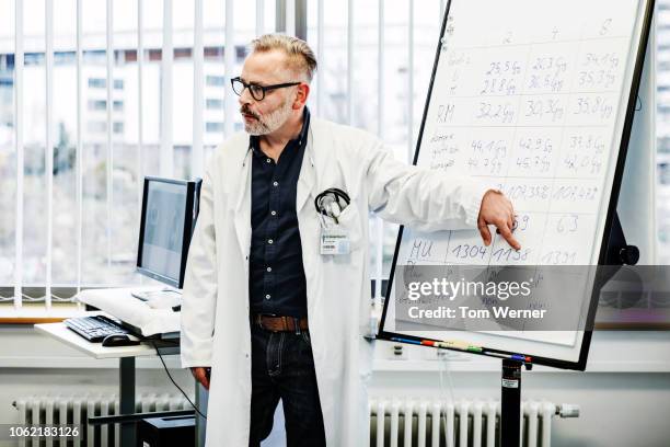 medical professor instructing students during seminar - academia stockfoto's en -beelden
