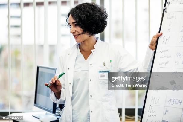 medical registrar talking during seminar - doctor presentation stock pictures, royalty-free photos & images