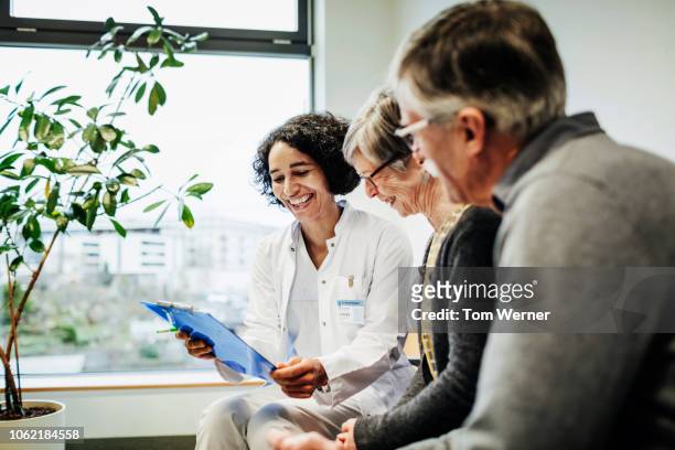doctor pleased with elderly couple's test results - senior patient stock-fotos und bilder