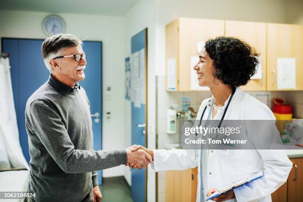 elderly man shaking doctor's hand - 50 year old male patient stock pictures, royalty-free photos & images