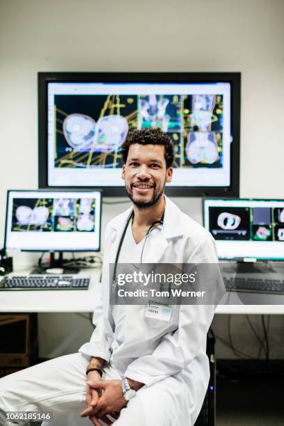 portrait of doctor sitting at lab desk - oncologist stock pictures, royalty-free photos & images