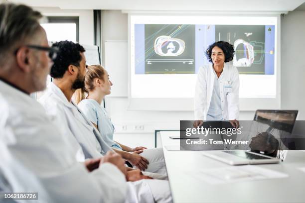 doctors discussing research data togeher - female doctors group stock pictures, royalty-free photos & images