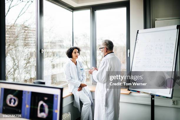 two doctors discussing test results in the lab - outil de diagnostic médical photos et images de collection