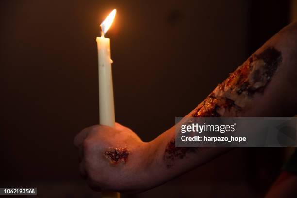 zombie hand with rotting flesh makeup holding a candle at night. - death of a rotten 個照片及圖片檔