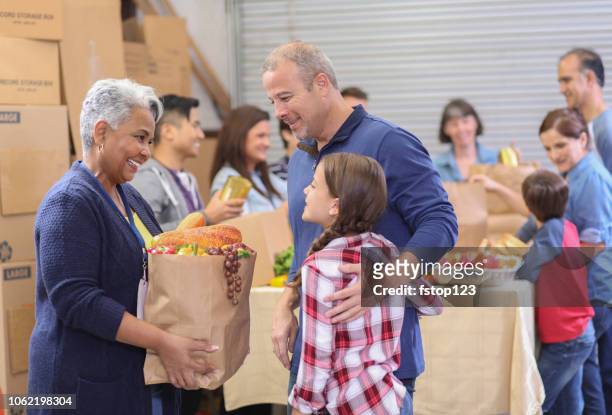 multi-etnische groep vrijwilligers werk bij de voedselbank. - thanksgiving food stockfoto's en -beelden