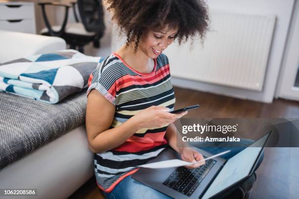 young woman paying the bills at home - scanned document stock pictures, royalty-free photos & images