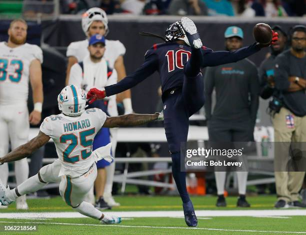 DeAndre Hopkins of the Houston Texans makes a one handed catch as Xavien Howard of the Miami Dolphins falls down at NRG Stadium on October 25, 2018...