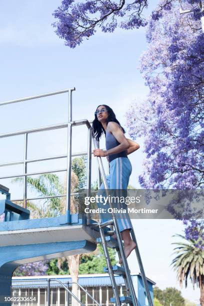 woman climbing the steps of a diving board. - johannesburg stockfoto's en -beelden